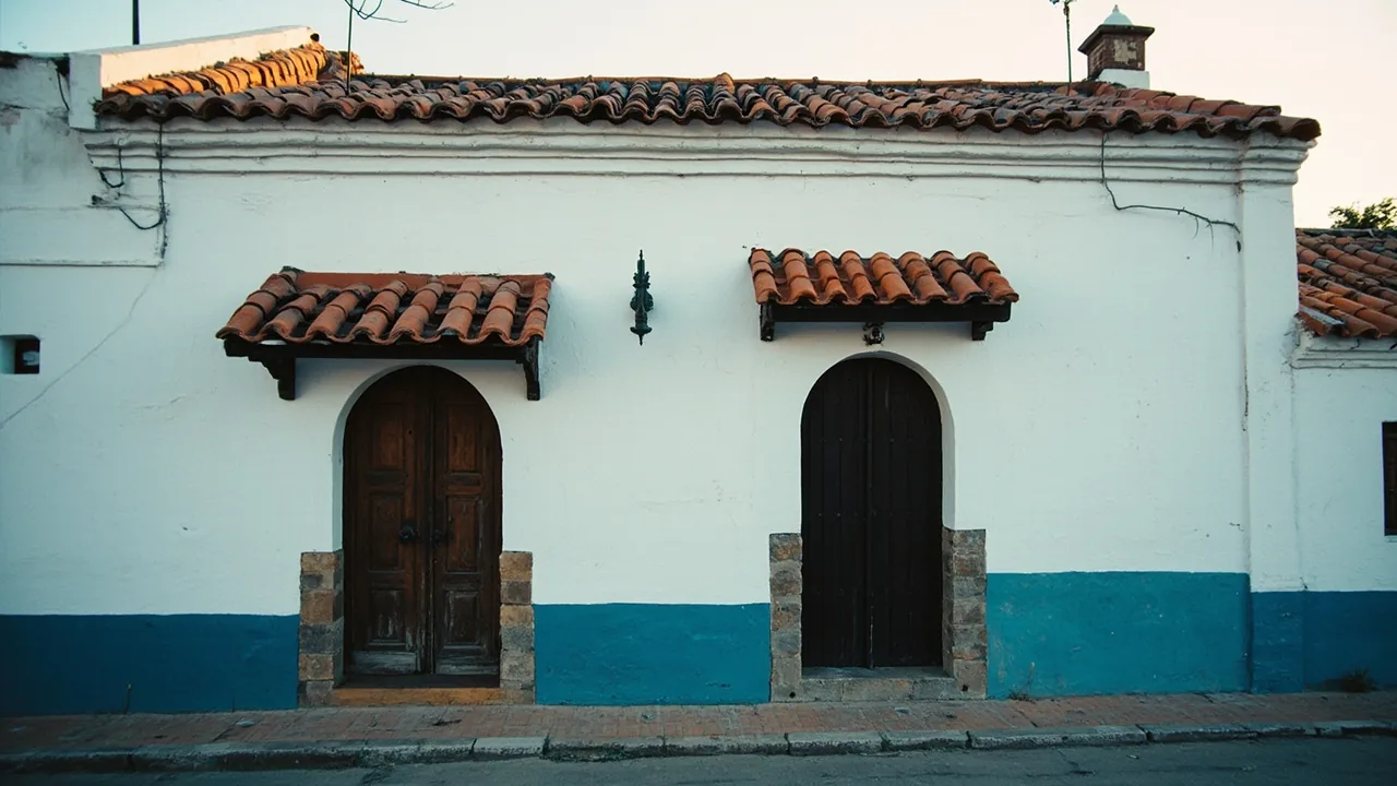 Aceptación de la herencia: fachada encalada de una casa de pueblo española con puerta de madera